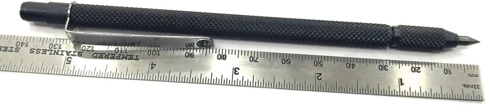 Black metal scriber beside ruler