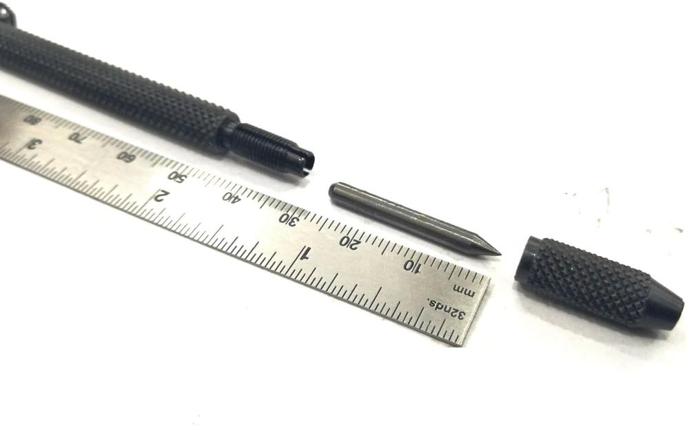 Black metal scriber beside ruler