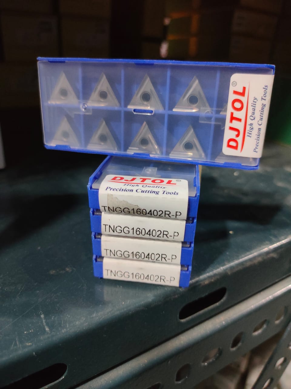 Stack of DJTOL cutting tools in a blue box