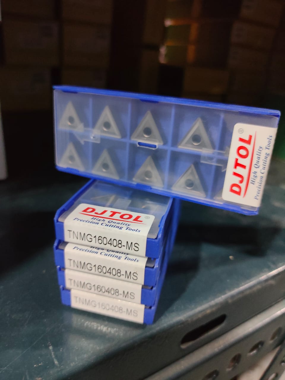 Stack of DJTOL cutting tools in blue boxes