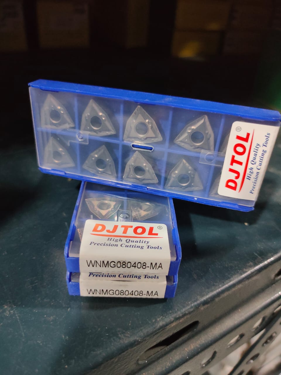 Two blue boxes containing DJTOL precision cutting tools