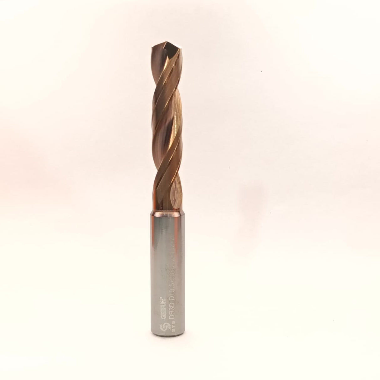 Metal drill bit on a light beige