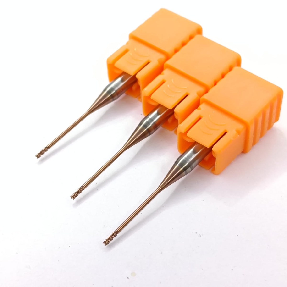 Three orange drill bits with metal tips