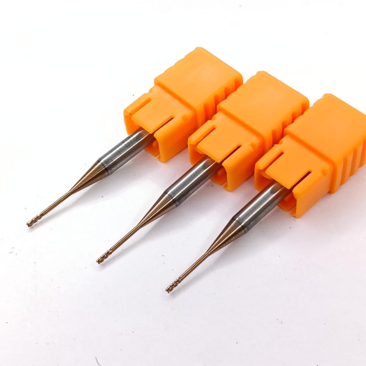 Three metal drill bits with orange handles
