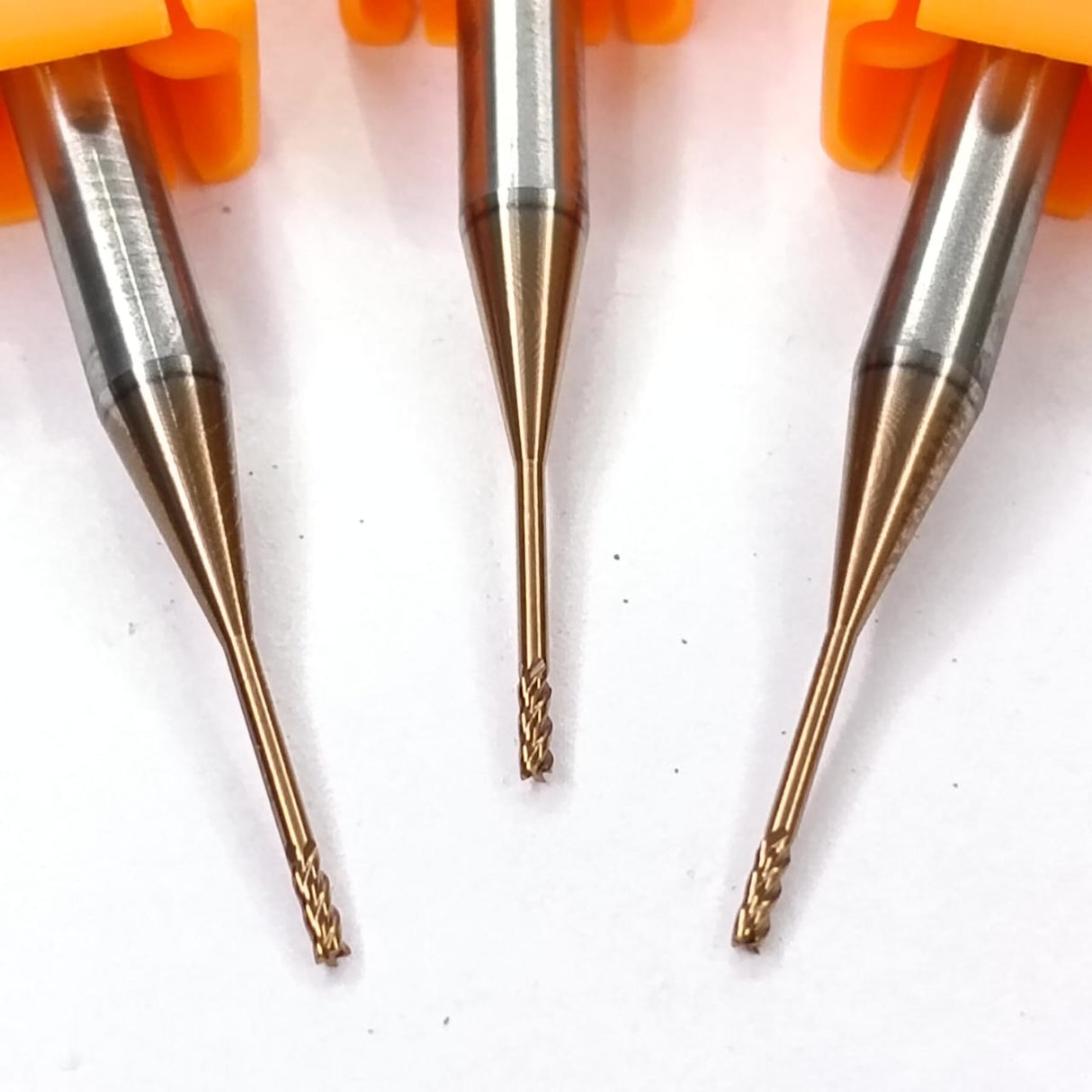 Three metal drill bits with orange handles