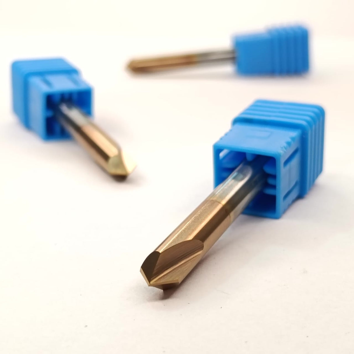 Three metal drill bits with blue plastic handles