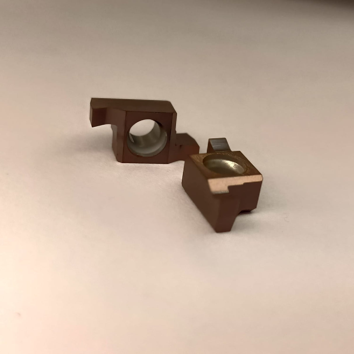 Two brown metal components