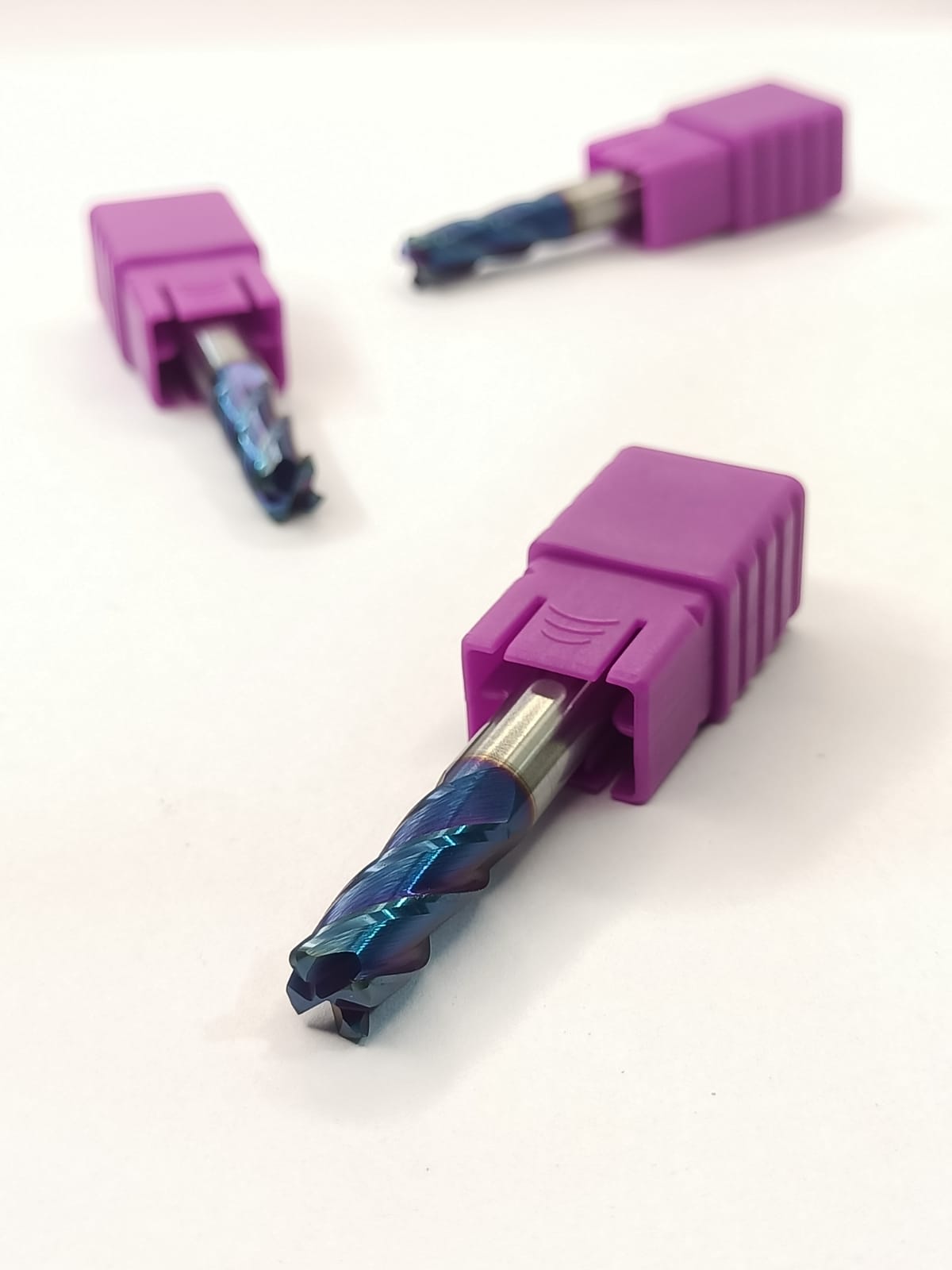 Three purple drill bits with blue cutting ends