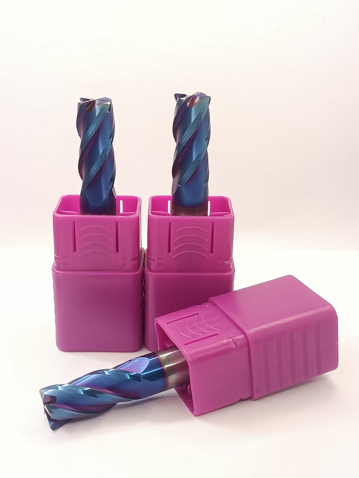 Three drill bits in pink holders