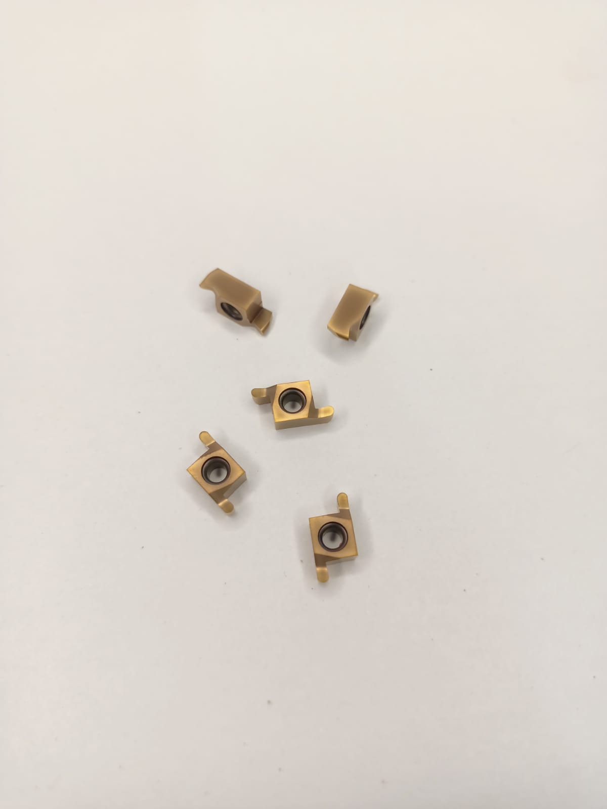 Five brass-colored metal components