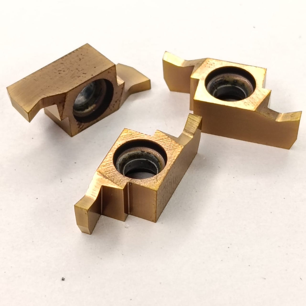 Three brass metal components