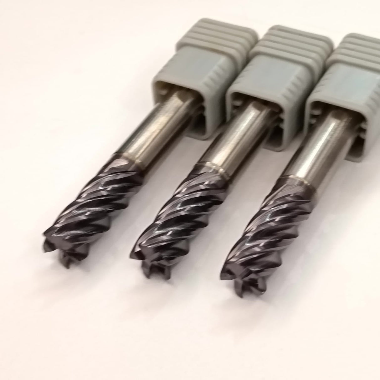 Three metal drill bits with gray handles