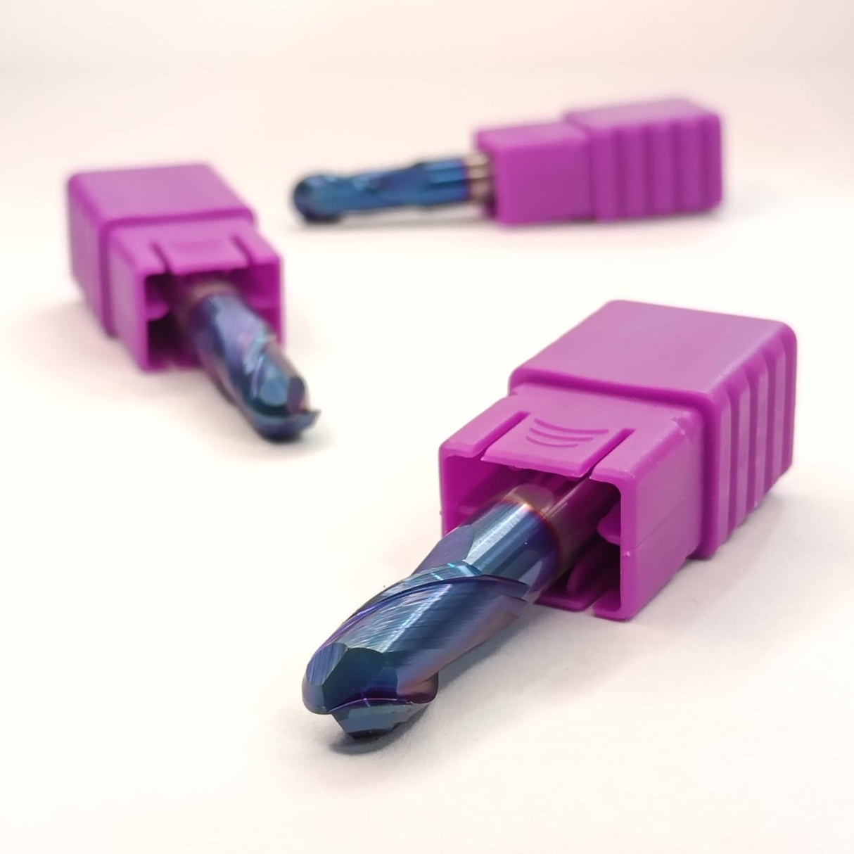 Three purple drill bits with blue metal tips
