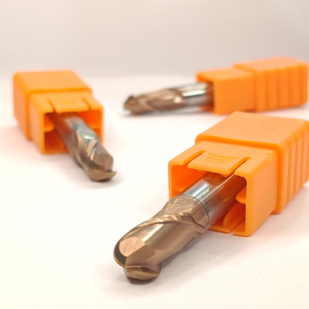 Three metal drill bits in orange holders