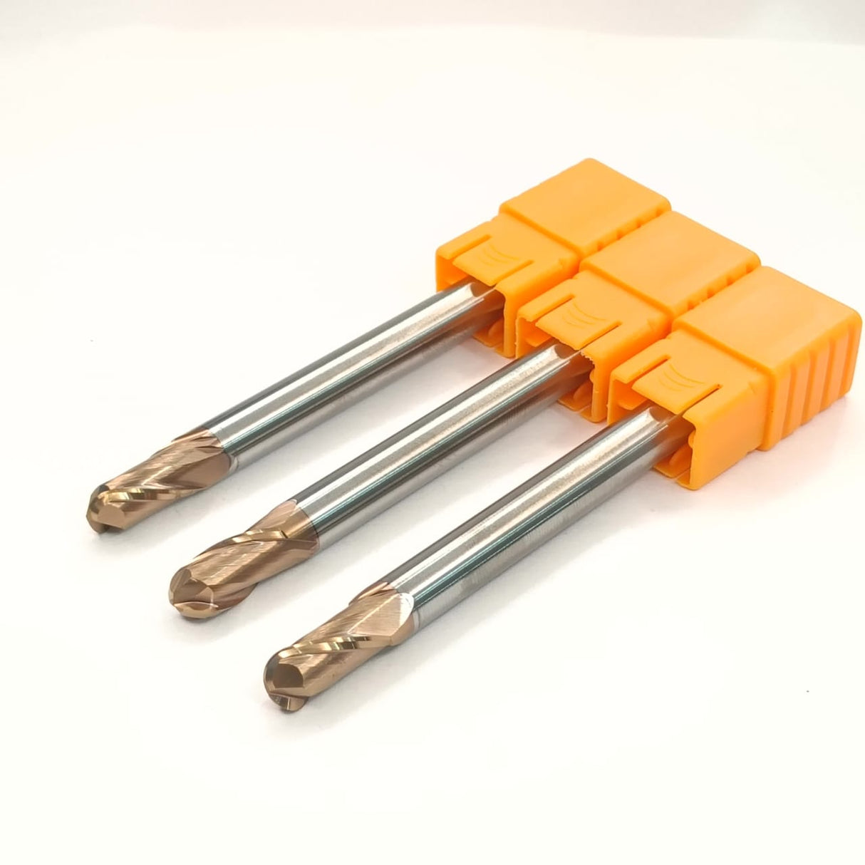 Three metal drill bits in an orange holder