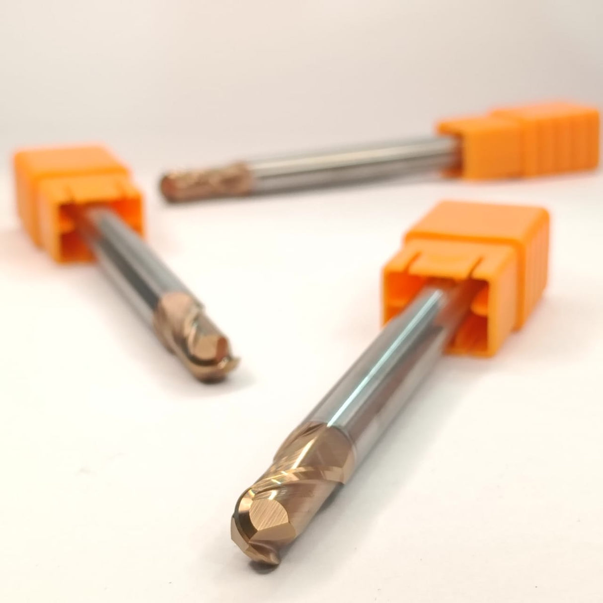 Three metal drill bits with orange handles