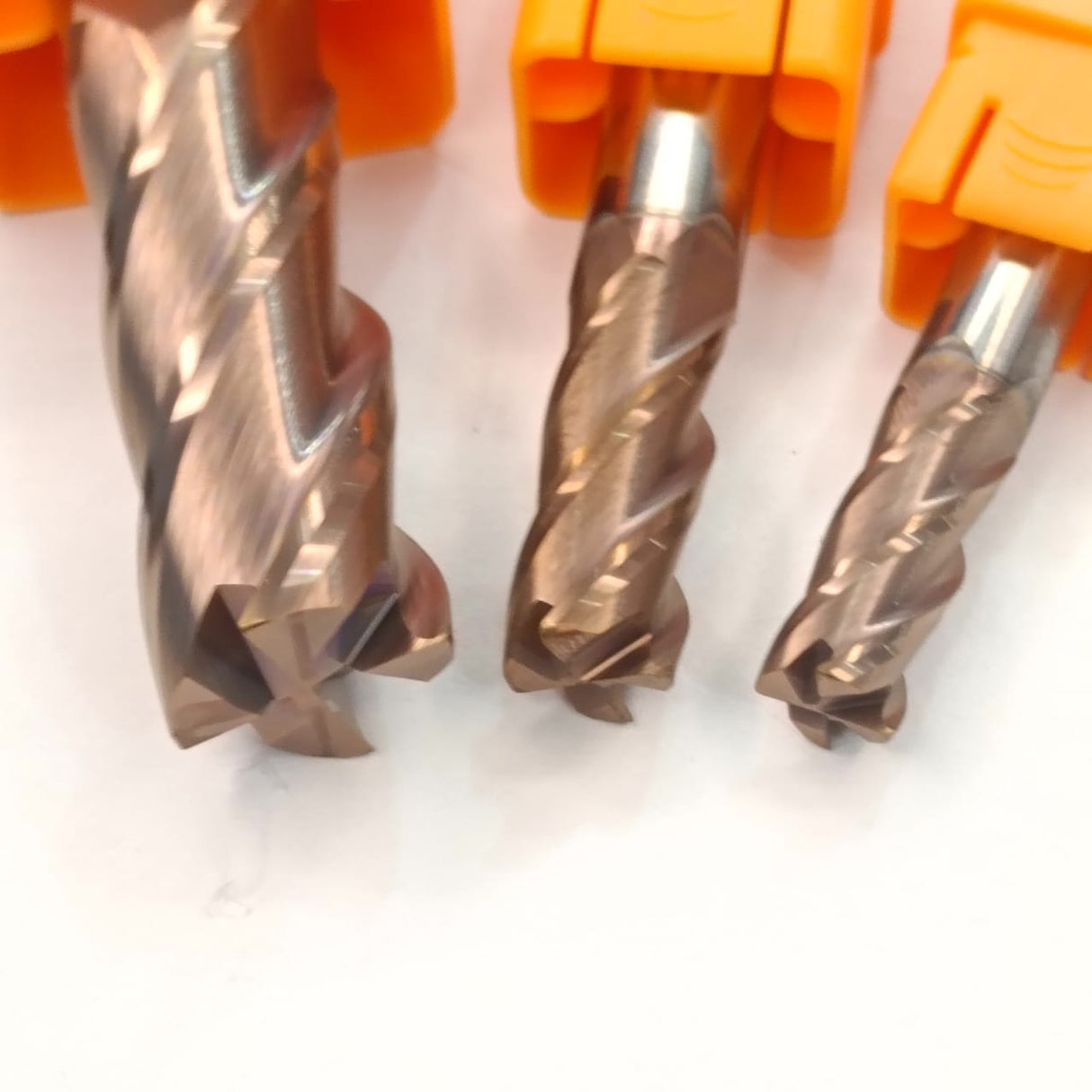 Three metal drill bits with orange handles