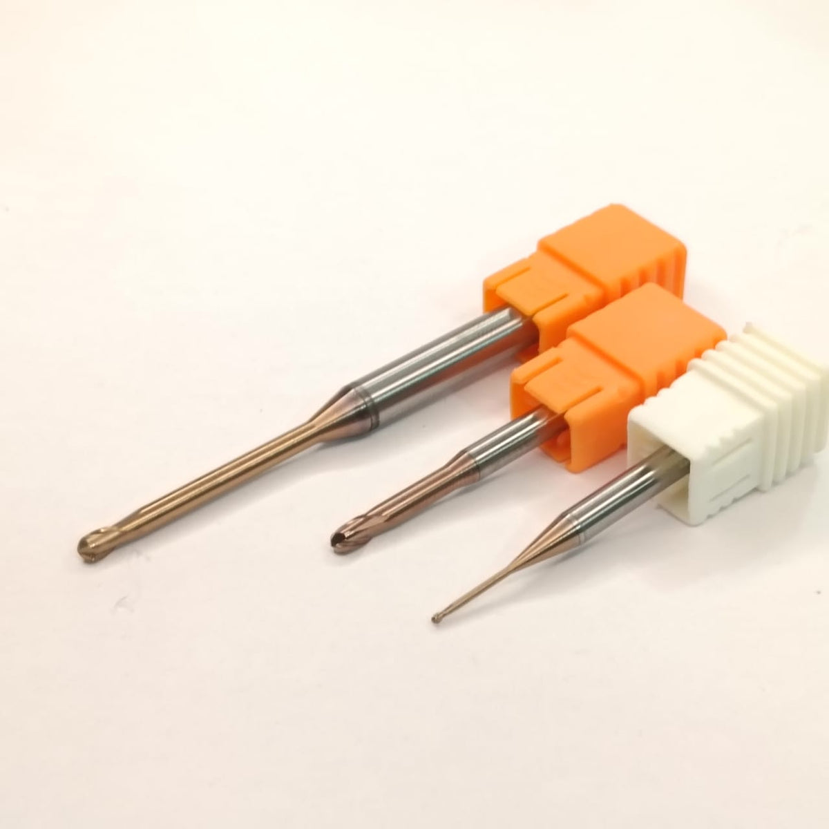 Three metal drill bits with orange and white handles