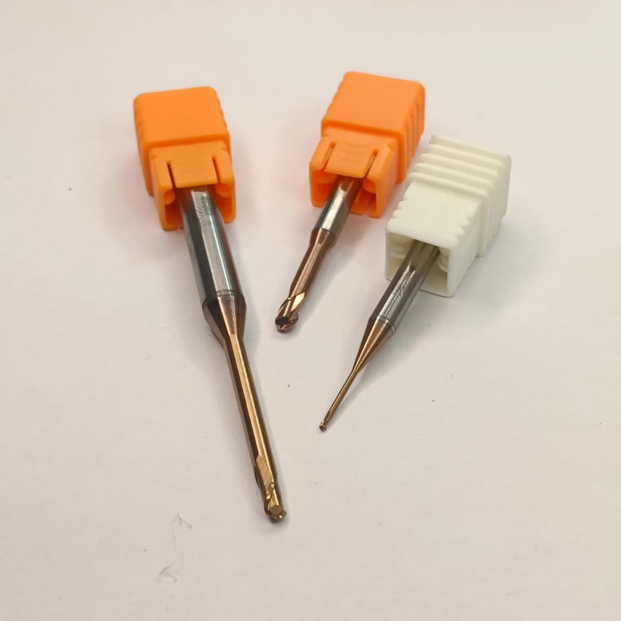 Three dental drill bits with orange and white handles