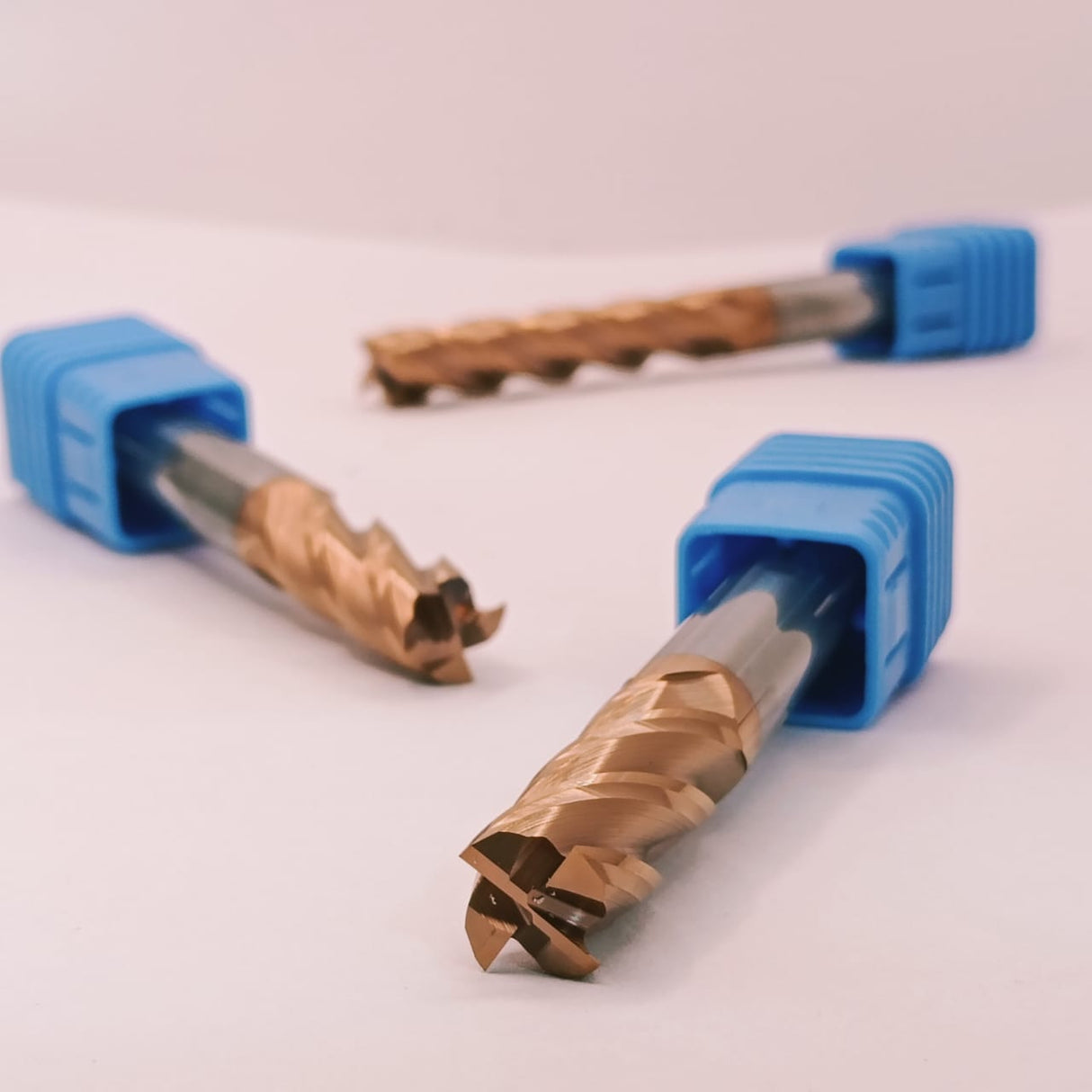 Three metal drill bits with blue plastic handles