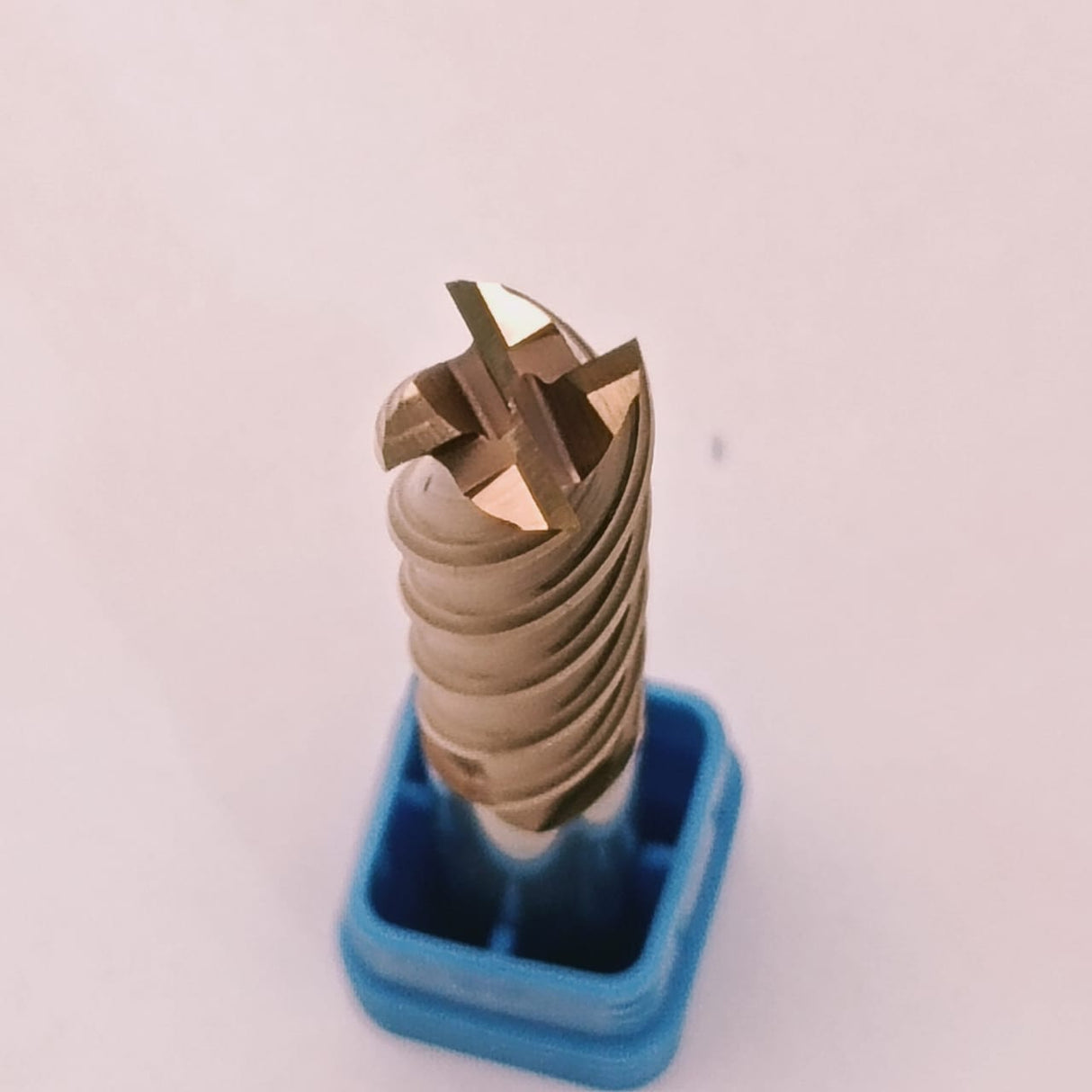 Metal drill bit on a blue stand against