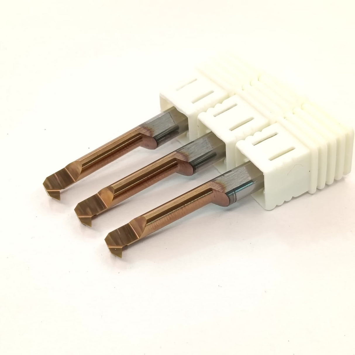 Three metal drill bits in a white plastic holder