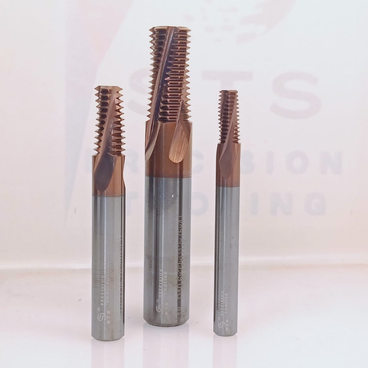 Three coated metal thread taps.