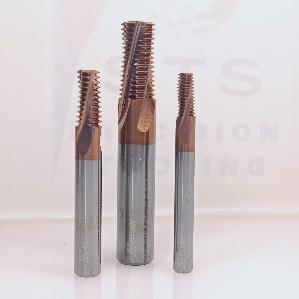 Three coated metal thread taps.
