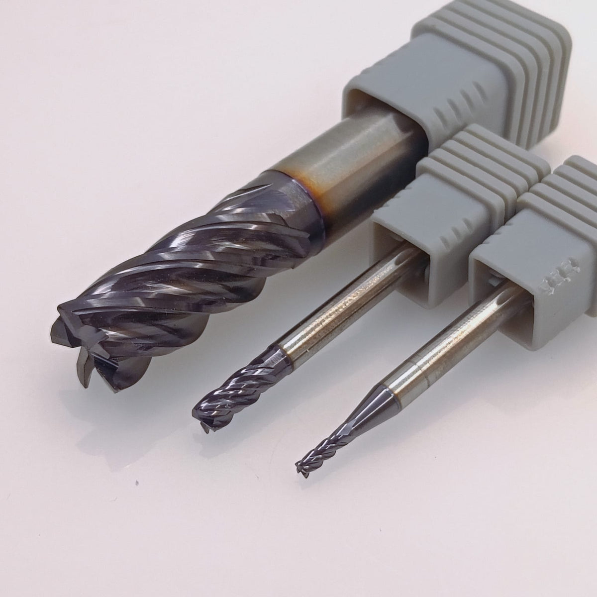 Three industrial carbide end mills
