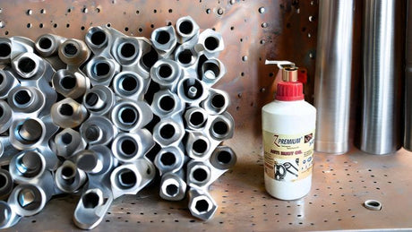 Stack of metal pipes and a bottle of lubricant 