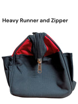 Gray bag with a red interior and zipper 