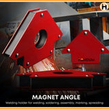 Red magnetic welding clamps holding metal with sparks in background